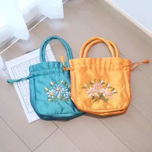 Detailed shot of classical Chinese style silk embroidered drawstring handbag with floral ribbon motifs.