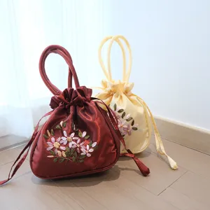 Detailed shot of traditional Chinese silk embroidered drawstring handbag with floral patterns.
