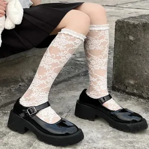 Detailed view of white lace ruffle JK lolita socks paired with black Mary Jane shoes.