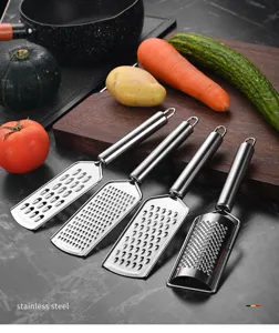 Edelstahl Küchenreibe Detailansicht mit vier verschiedenen Klingen für Käse, Zitrone und Ingwer.