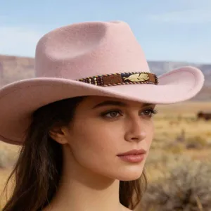 Close-up of pink felt cowboy hat featuring a colorful beaded and golden feather band.