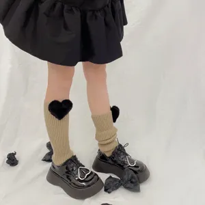 Knit leg warmers with cute black fluffy heart decor, cozy winter accessories for stylish outfits.