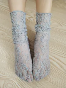 Close-up detail of grey lace hollow-out net ruffles mid-calf socks showing delicate texture.