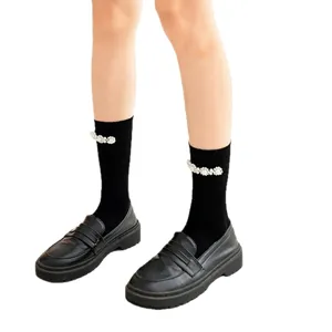 Black mid-calf socks for women featuring elegant pearl decorations, paired with stylish black loafers.