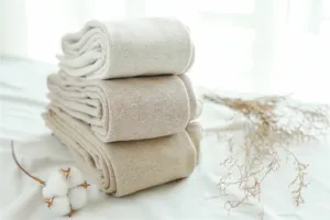 Close-up detail of thick ribbed fleece-lined winter tights in soft oatmeal and beige tones.