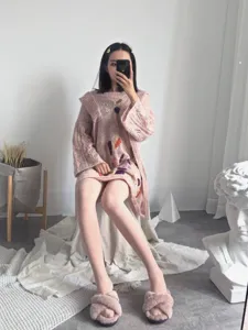 Detailed view of women's soft pink matte seamless tights and cozy knitted sweater outfit.