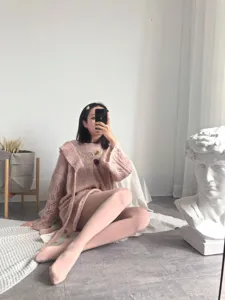 Pink knitted cardigan and matte tights detail shot, soft cozy autumn winter style outfit.