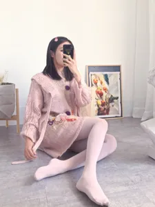 Detail view of women pink knit cardigan and seamless tights, sweet winter style outfit.