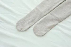 Detail shot of oatmeal ribbed tights, soft fleece-lined texture, cozy winter base layer.