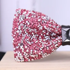 Detailed shot of a sparkly pink rhinestone bow tie with silver spikes for formal events.