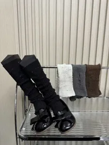 Détail de jambières en tricot, chaussettes montantes texturées à effet destroy.