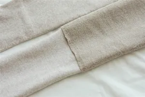 Detailed view of thick fleece-lined ribbed knit leggings in oatmeal beige, soft winter fabric texture.