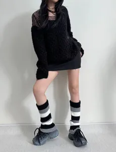 Détail de jambières en tricot avec motif rayé noir et blanc pour le style automne hiver.