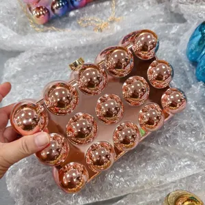 Close-up detail of the rose gold acrylic spherical clutch bag, showing the 3d ball studs design.