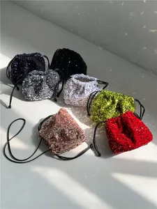 Vue détaillée de sacs seau à cordon en sequins colorés au design plissé souple et brillant.
