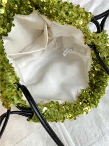 Détail intérieur du sac seau à sequins verts, avec doublure douce et poches intérieures.