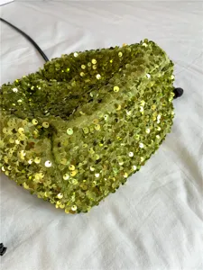 Vue détaillée de la texture du sac seau à sequins verts et de sa matière douce.