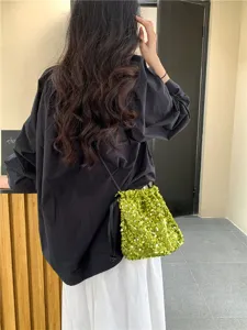 Sac seau bandoulière en sequins verts brillants avec cordon de serrage et lanière souple.