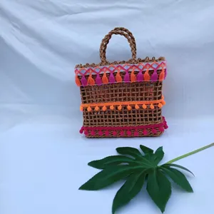 Bolso de mano de paja tejida bohemio con borlas coloridas y detalles para verano playa.