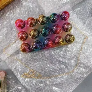 Rainbow gradient acrylic bubble clutch bag with gold chain strap, stylish shoulder handbag.