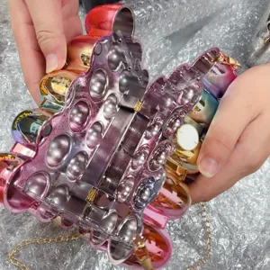 Detailed view of the shiny gradient acrylic evening clutch box bag with inner chain design.