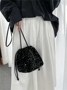 Vue détaillée du sac seau à sequins noirs mettant en valeur les paillettes et le cordon.