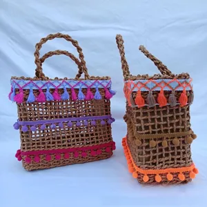 Vista detallada de bolso tejido de playa de verano boho con borlas étnicas para vacaciones.