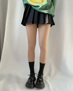 Detailed shot of women fake translucent fleece tights paired with black skirt and shoes.