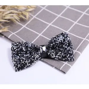 Sparkling black rhinestone bow tie close-up, premium crystal groom wedding formal suit detail.