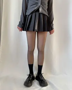Detailed shot of the fake translucent pantyhose paired with pleated skirt and shoes.