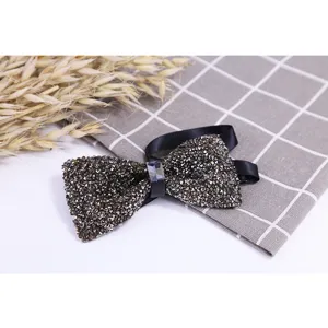 Detailed view of a sparkling crystal rhinestone bow tie with black satin ribbon and metal clasp.
