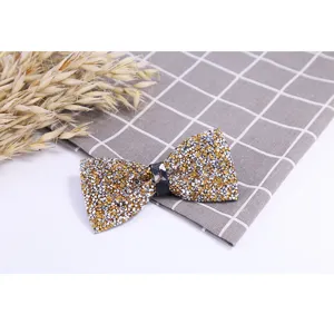 Detail view of a stunning crystal rhinestone bow tie in gold and silver, perfect for wedding grooms.