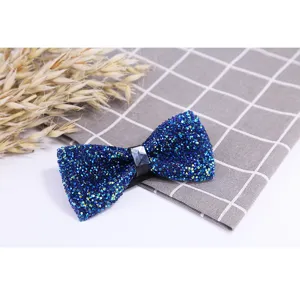 Crystal bow tie detail showing sparkling blue rhinestones and fabric texture for wedding wear.