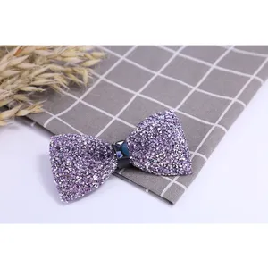 Detailed view of a sparkling purple crystal bow tie, elegant men's accessory for wedding.