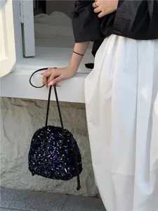 Vue détaillée du sac seau à sequins noirs mettant en valeur sa texture brillante et son design chic.