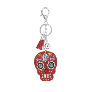 Detailed view of the rhinestone skull keychain pendant showing sparkling crystals and red tassel.