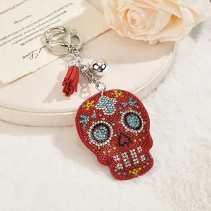Detailed view of a sparkling rhinestone skull keychain and bag charm in red velvet style.
