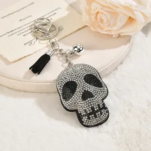 Rhinestone skull keychain with black tassel and bell, stylish hip-hop bag pendant accessory.