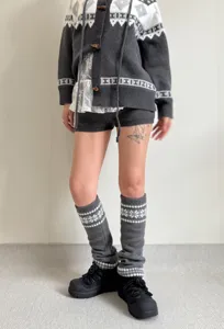 Vue détaillée de jambières en tricot gris avec motif flocon de neige style hivernal.