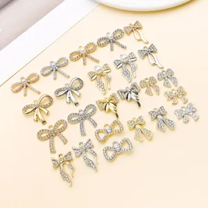 Gold and silver bow charms with rhinestones and pearls for DIY jewelry making and crafting.