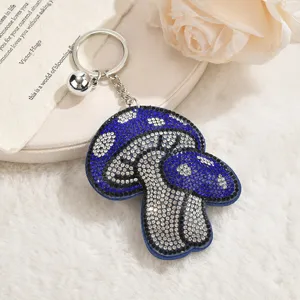 Detalle de llavero de hongo con pedrería azul, colgante brillante para bolso con anillo de metal.