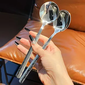 Close-up of stainless steel serving spoon with textured handle and polished mirror bowl.