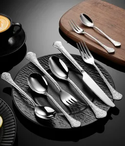 Detailed view of stainless steel hammered cutlery set, including steak knife, fork and spoon.