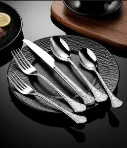 Detailed close-up view of hammered stainless steel cutlery set, showcasing exquisite design.
