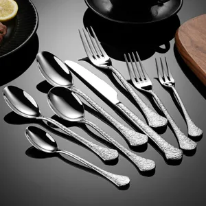Stainless steel cutlery set with hammered handles, including dinner knives, forks, and spoons.