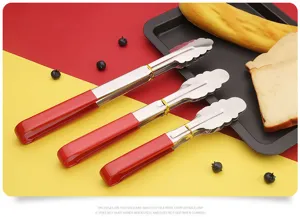 Detailed close-up of stainless steel food tongs with red rubber handle for kitchen cooking.