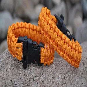 Orange paracord survival bracelet with whistle buckle, durable outdoor tactical gear.