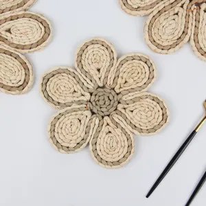 Detailed close-up view of handmade woven straw floral placemat coaster bohemian home decor.