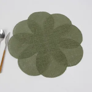 Close up view of green woven petal table mat detail, heat insulation placemat for dining table.