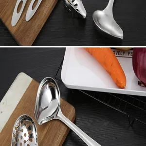 Stainless steel sloped soup spoon and colander detail view, kitchen cooking utensil.